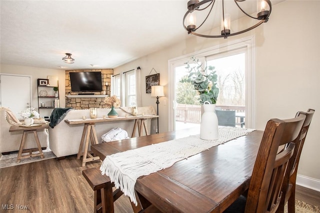 dining area featuring an inviting chandelier, baseboards, and wood finished floors