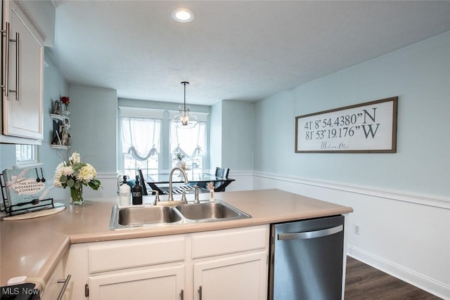 kitchen with dark wood-style floors, a sink, light countertops, white cabinetry, and stainless steel dishwasher