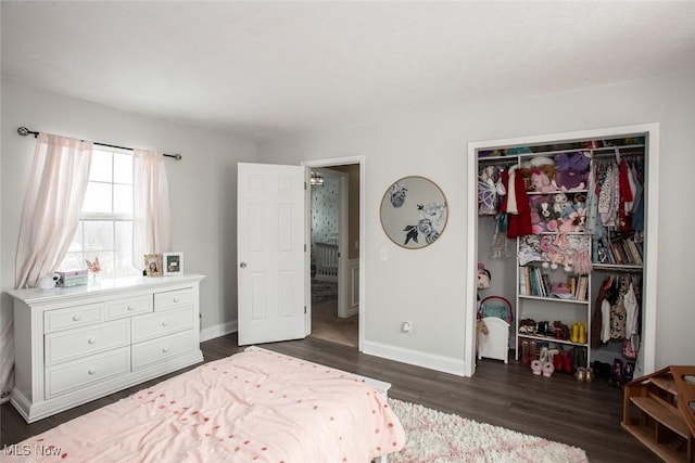 bedroom featuring a closet, baseboards, and dark wood-type flooring