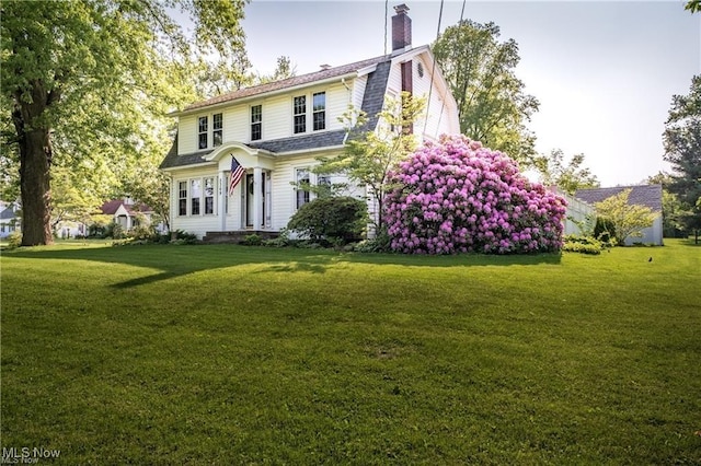 dutch colonial with a front yard and a gambrel roof