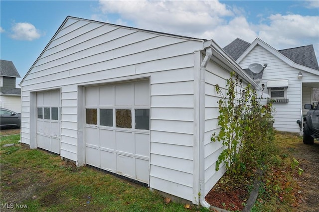 view of property exterior featuring a garage, roof with shingles, and an outdoor structure