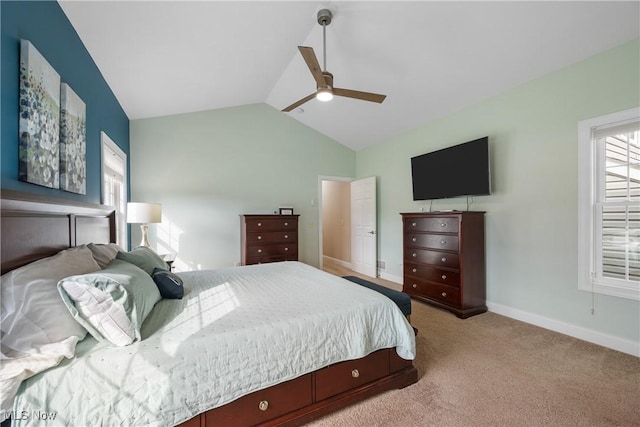 bedroom with lofted ceiling, light carpet, a ceiling fan, and baseboards