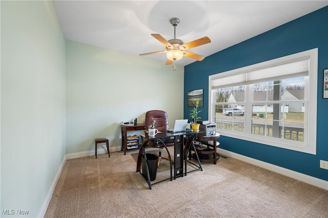 carpeted home office featuring a ceiling fan and baseboards