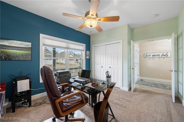 home office featuring light carpet, ceiling fan, light tile patterned floors, and baseboards