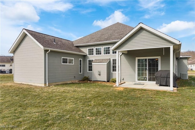 back of house with a patio, a yard, and roof with shingles