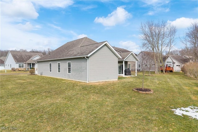 back of property featuring a residential view and a yard