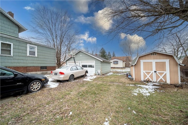 view of yard with a storage shed, a detached garage, and an outdoor structure