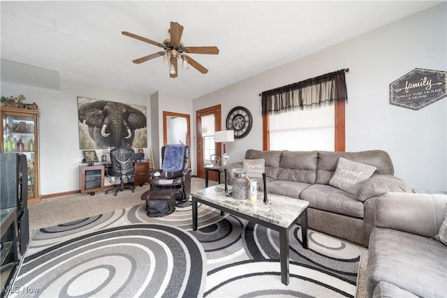 carpeted living room with ceiling fan and baseboards