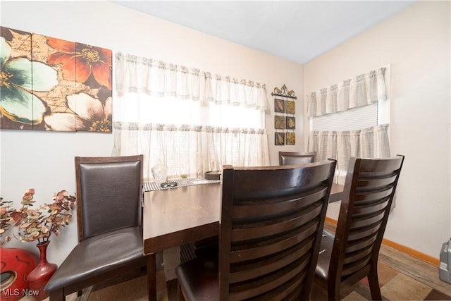 dining space with baseboards and wood finished floors