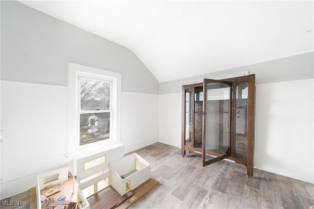 interior space with vaulted ceiling and light wood-style flooring