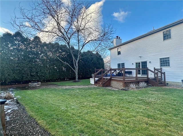 view of yard featuring an outdoor fire pit and a deck