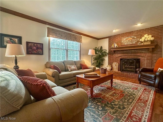 living room with ornamental molding, a brick fireplace, and wood finished floors