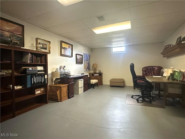 office with a drop ceiling and finished concrete floors