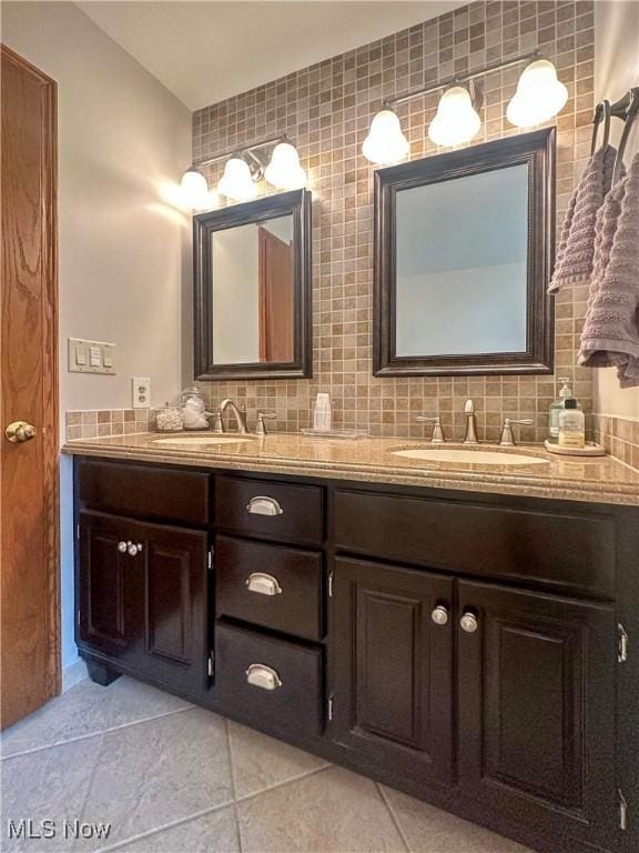 full bathroom with double vanity, tasteful backsplash, a sink, and tile patterned floors