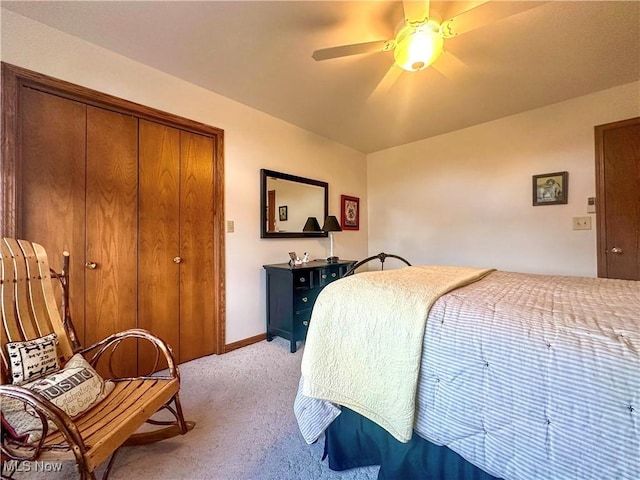 bedroom with light carpet, a closet, baseboards, and a ceiling fan