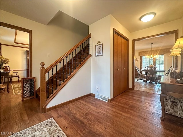 foyer entrance with visible vents, dark wood finished floors, stairway, and baseboards