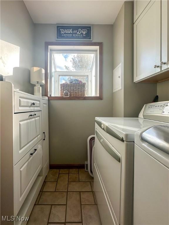 washroom with tile patterned flooring, washing machine and clothes dryer, cabinet space, and baseboards