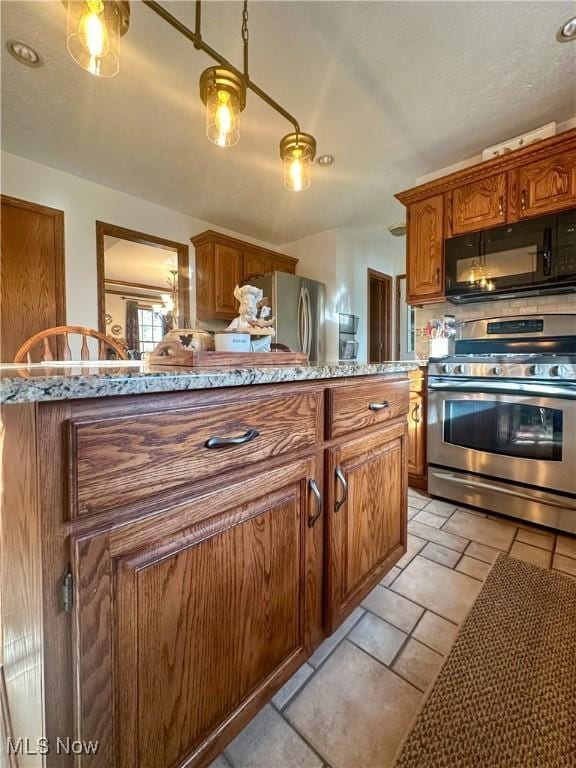 kitchen featuring light countertops, appliances with stainless steel finishes, and brown cabinets