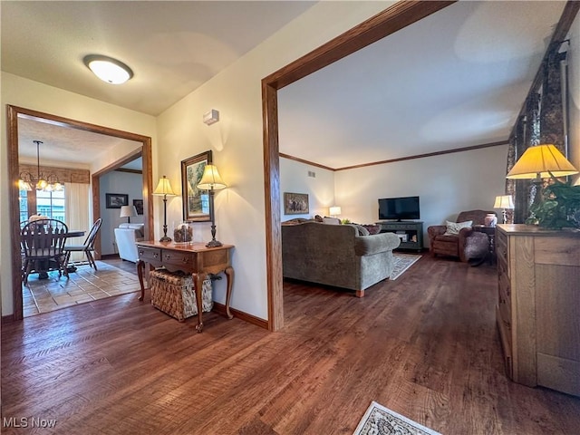 hall featuring dark wood-style floors, ornamental molding, baseboards, and an inviting chandelier