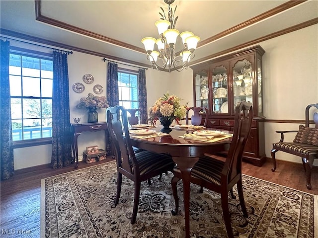 dining room featuring baseboards, ornamental molding, dark wood-style flooring, an inviting chandelier, and a tray ceiling