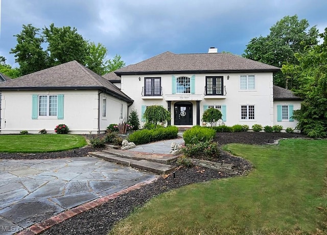 315 Glengarry Dr, Aurora, OH 44202 - view of front of home with a shingled roof, stucco siding, a chimney, and a front yard