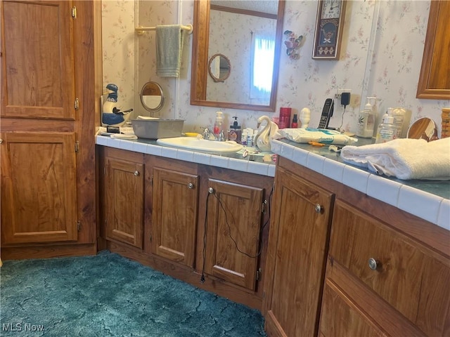 bathroom with vanity and wallpapered walls