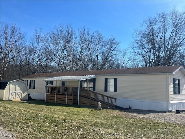 manufactured / mobile home with a wooden deck, a storage unit, a front lawn, and an outdoor structure