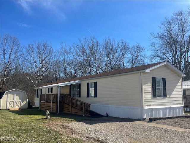 manufactured / mobile home with a shed, a front lawn, and an outdoor structure