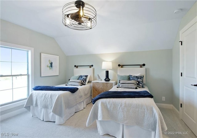 bedroom featuring lofted ceiling, baseboards, and light colored carpet