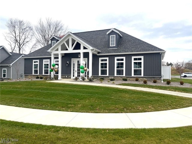 view of front of house with a front lawn, board and batten siding, and a shingled roof