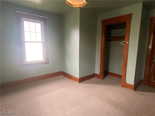 unfurnished bedroom featuring carpet floors, a closet, and baseboards