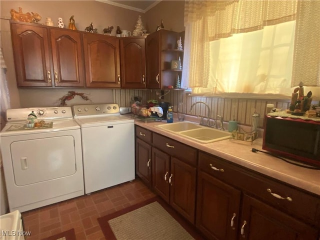 clothes washing area with separate washer and dryer and a sink