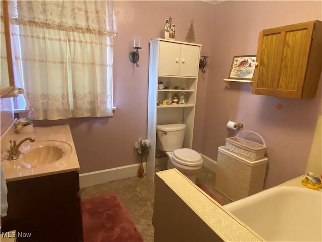 bathroom featuring vanity, toilet, and baseboards