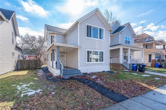 traditional home with covered porch and fence