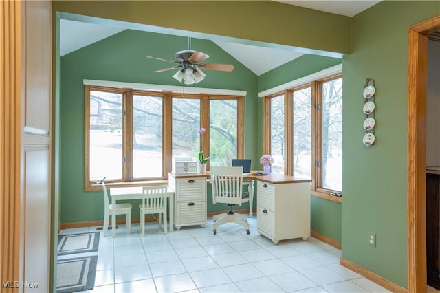 unfurnished office featuring lofted ceiling, a healthy amount of sunlight, baseboards, and light tile patterned flooring