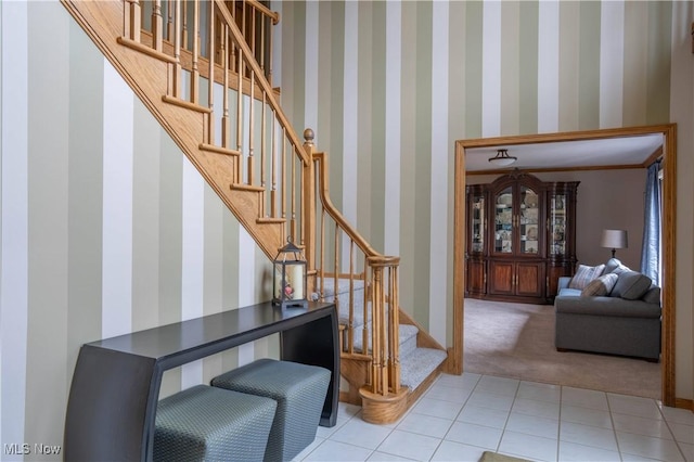 stairs featuring carpet, tile patterned floors, baseboards, and wallpapered walls