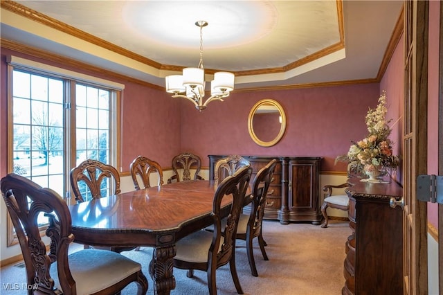 dining area featuring light carpet, a chandelier, a raised ceiling, and crown molding