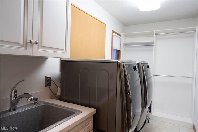 laundry room featuring a sink, cabinet space, washer and dryer, and light tile patterned flooring