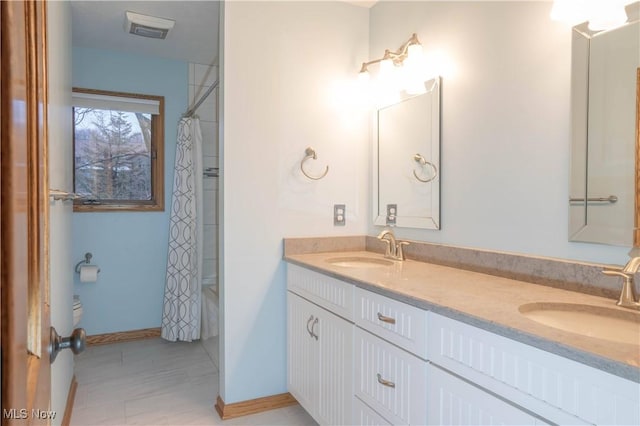 bathroom featuring shower / tub combo with curtain, a sink, baseboards, and double vanity