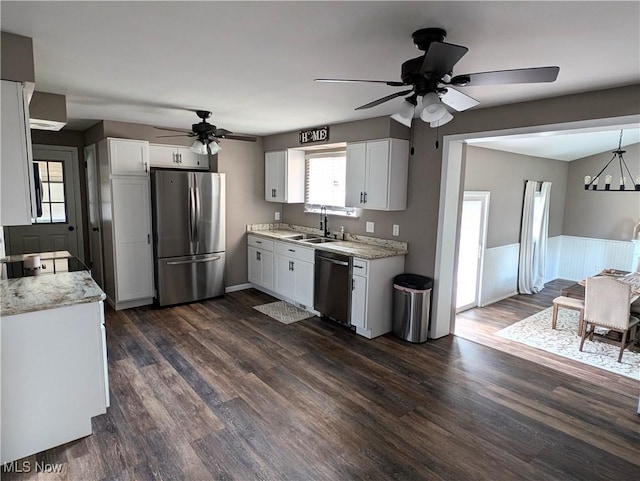 kitchen with stainless steel appliances, dark wood-type flooring, a sink, white cabinetry, and light countertops