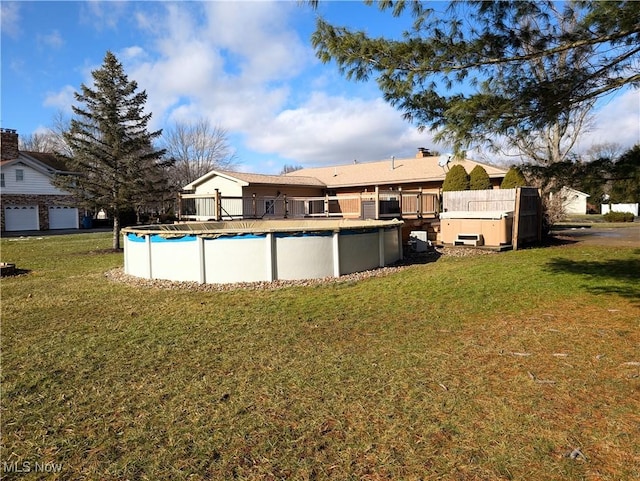 back of property with a covered pool and a yard