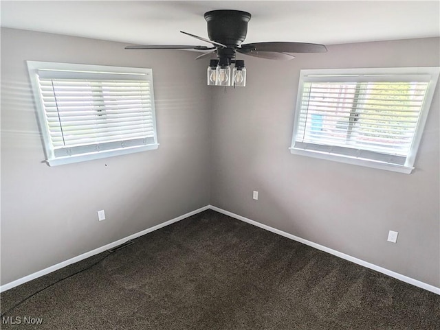 carpeted empty room with ceiling fan and baseboards