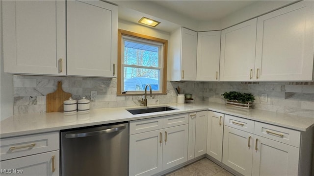 kitchen with a sink, white cabinetry, light countertops, and stainless steel dishwasher