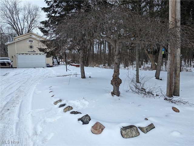 yard covered in snow featuring a garage