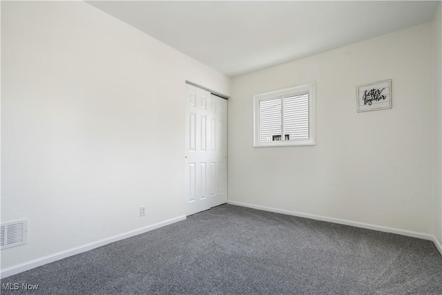 carpeted spare room with visible vents and baseboards