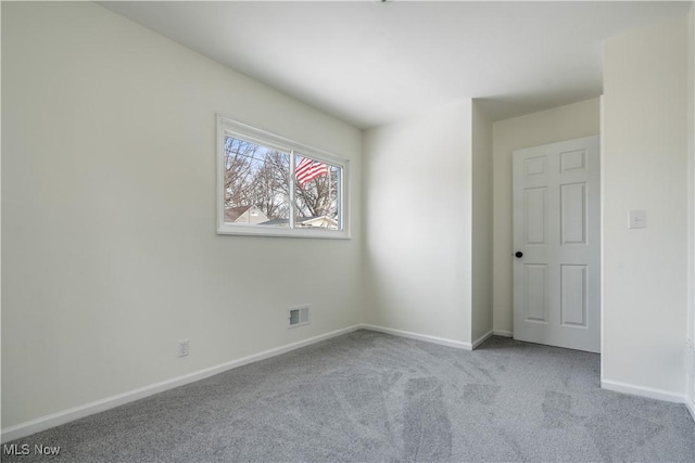 unfurnished room with baseboards, visible vents, and light colored carpet