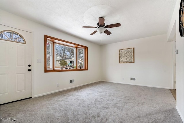 entryway with a wealth of natural light, light colored carpet, and visible vents