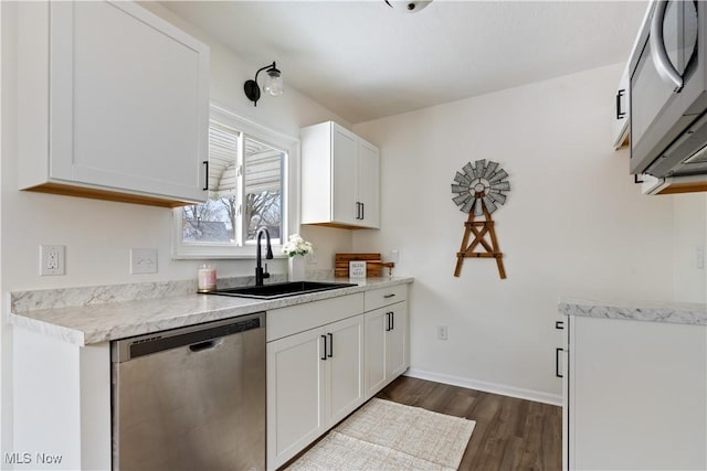 kitchen with stainless steel appliances, light countertops, a sink, and white cabinetry