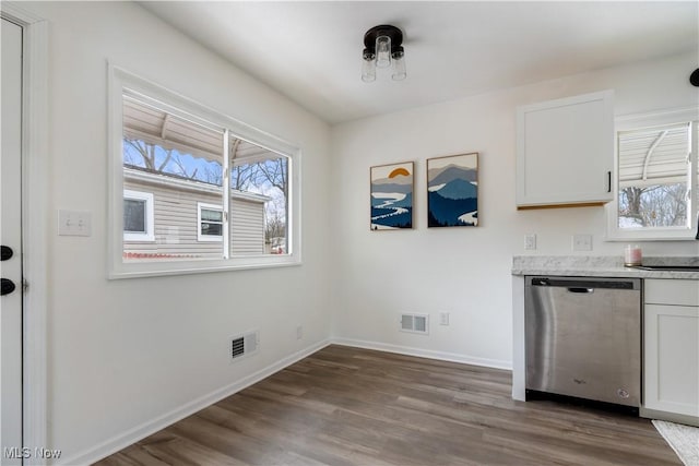 kitchen with baseboards, white cabinets, visible vents, and stainless steel dishwasher