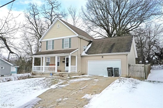 view of front facade with covered porch, fence, and an attached garage